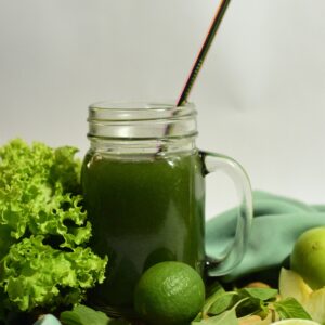 Refreshing green juice with lime and lettuce, served with a metal straw in a mason jar.