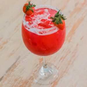 Vibrant red strawberry cocktail with ice, perfect for a refreshing summer drink.