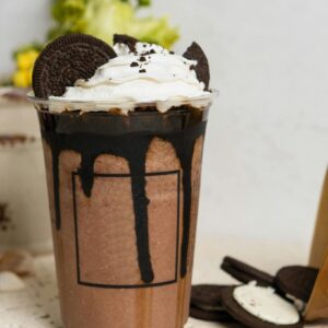 A mouthwatering chocolate milkshake topped with whipped cream and Oreo cookies, perfect for sweet cravings.