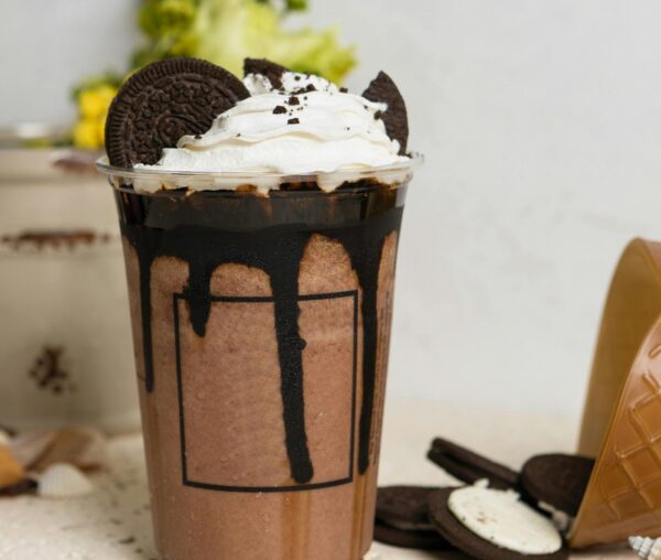 A mouthwatering chocolate milkshake topped with whipped cream and Oreo cookies, perfect for sweet cravings.